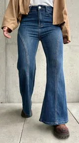 Jean de tiro alto con corte semi oxford, confeccionado en denim con elasticidad. Presenta un diseño con costuras verticales decorativas en el frente que estilizan la silueta.