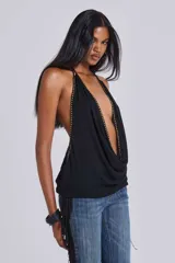 Top negro con escote drapeado profundo, tirantes finos y detalles de tachas doradas a lo largo del escote y los laterales.