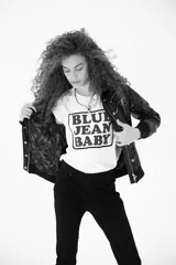 Remera de algodón blanca con cuello redondo y estampa frontal con el texto 'BLUE JEAN BABY' enmarcado en un recuadro negro.