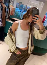 Musculosa blanca de algodón con ribetes en tono tostado en el escote y las sisas, de corte al cuerpo.