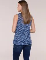 Blusa sin mangas de corte semi entallado, confeccionada en algodón con estampado geométrico en blanco y negro. Presenta escote redondo y largo hasta la cadera.