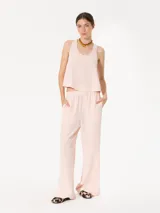 Pantalón de satén doble color rosa pálido, de corte ancho y tiro alto con cintura elastizada. Presenta broches grabados con logo JCH en los laterales.