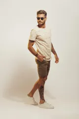 Remera de cuello redondo y manga corta, color beige con estampado de pequeños motivos playeros.