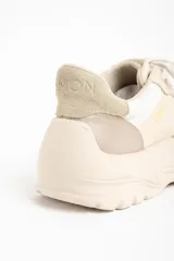 Zapatilla urbana de mujer con plataforma gruesa, combinando paneles de cuero liso y gamuza en tonos beige y nude. Presenta cordones blancos y la palabra "LEMON" estampada en dorado en el lateral.