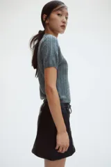 Pollera mini negra entallada de corte evasé, con cierre oculto y corchete en un lateral.