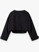 Campera corta oversize de color negro, confeccionada en algodón, con mangas largas, cuello redondo, cierre frontal de botones y bajo con elástico fruncido.