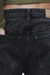 Jeans de tiro medio con diseño baggy barrel, confeccionados en denim color beige con efecto lavado. Presentan cinco bolsillos, costuras laterales torcidas y cierre frontal con cremallera y botón metálico.