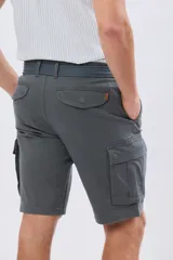 Bermuda cargo color azul marino, de gabardina con bolsillos laterales con solapa en las piernas y presillas para cinturón. Incluye cinturón de lona trenzada oscura con detalles en cuero sintético y hebilla metálica.