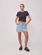 Falda de jean de corte recto y tiro medio, con diseño clásico de cinco bolsillos, cierre frontal con botón y costuras en contraste.