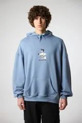 Buzo hoodie celeste con cordones ajustables, bolsillo tipo canguro y puños elásticos. Estampado frontal con dibujo de surfista y texto "blue bananas".