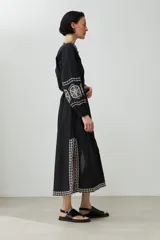 Túnica larga color crudo con bordados rojos en cuello, mangas y ruedo.