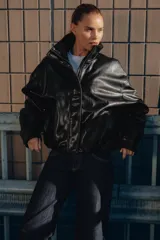 Chaqueta de efecto piel con cuello subido, manga larga con puños y bajo elástico. Presenta cierre frontal con cremallera y botones a presión ocultos, además de bolsillos laterales y forro interior.