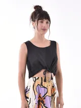 Top negro sin mangas con escote redondo y lazo ajustable en el ruedo.