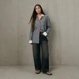 Camisa de rayas gris con cuello y puños en contraste blancos, de manga larga y diseño oversize con bolsillo en el pecho.