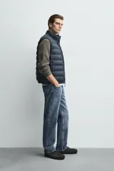 Chaleco acolchado de hombre color negro, con diseño puffer, cuello alto y cierre frontal con cremallera.