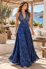 Vestido largo de seda color azul con estampado circular, escote halter pronunciado y aberturas laterales en la cintura.