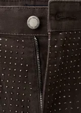 Pantalón de jean de tiro bajo y diseño wide leg, color marrón oscuro, con aplicación de strass en toda la superficie. Cuenta con cinco bolsillos, trabillas para cinto y cierre frontal con botón y cremallera.