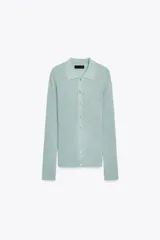 Chaqueta estilo polo de manga larga confeccionada en tejido de punto con hilo metalizado. Presenta cuello solapa y cierre frontal con botones.