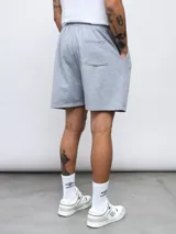 Bermuda de felpa Umbro de color azul, con cintura elástica con cordón de ajuste y bolsillos laterales. Presenta el logo de la marca bordado en blanco en el lateral izquierdo.
