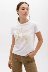 Remera blanca de algodón con estampado de dos flores en tonos pastel y logo de la marca en cursiva. Corte clásico y cuello redondo.