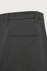 Pantalón de corte slim fit y color negro, confeccionado en tejido elástico. Cuenta con cintura elástica, trabillas, bolsillos frontales y cierre con cremallera y botón.