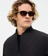 Campera masculina de corte regular, confeccionada en poliéster con acabado capitoneado texturizado en rombos. Presenta cierre frontal con cremallera, cuello redondo y puños con terminación en rib.