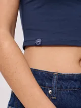 Musculosa ajustada color azul marino con cuello redondo y ribete blanco. Presenta un estampado frontal de una flor de hibisco blanca.