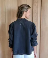 Blusa de algodón con cuello mao y volados, mangas largas con puños elásticos y corte holgado.