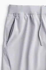 Short deportivo gris de tejido funcional con tecnología DryMove™ que absorbe el sudor. Diseño a media pierna con stretch en cuatro direcciones, cintura elástica con cordón ajustable oculto, bolsillos al bies, detalle reflectante en la parte posterior y aberturas laterales cortas en el bajo. Corte estándar.