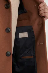 Sobretodo 3/4 de paño, color gris oscuro, con cuello solapa, cierre frontal de botones, manga larga y bolsillos laterales de ribete.