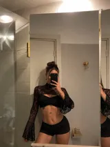 Top de encaje negro con cuello alto y mangas largas acampanadas, que incluye un corpiño tipo strapless integrado con fruncido central.