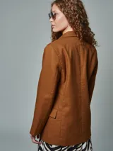 Blazer recto color crudo, de lino, con solapas de muesca, cierre cruzado con doble botonadura, mangas largas y bolsillos con solapa.