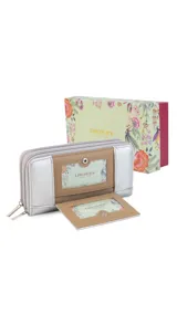 Billetera larga con diseño de doble compartimento y cierre perimetral. Presenta una combinación de cuero sintético en tonos beige y plateado, con solapa frontal que incluye visor y broche a presión. El interior cuenta con múltiples tarjeteros, bolsillos y monedero con cierre.