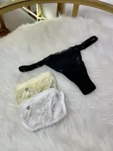 Pack de tres tangas de encaje con laterales regulables, que incluye una unidad en color negro, una en color blanco y una en color crema. Confeccionadas con tejido de encaje elástico y forro de algodón.