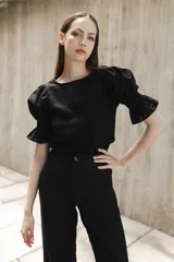 Blusa negra de tejido de punto con escote redondo y mangas cortas abullonadas con detalle de broderie.