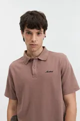 Remera polo de manga corta con textura tipo waffle, color marrón, con cuello clásico y logo bordado en el pecho.