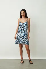 Vestido corto sin mangas con tirantes finos, escote redondo y diseño estampado en tonos azul, negro y blanco, con detalle de volados en el borde inferior.