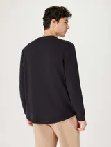 Camiseta de manga larga con cuello henley y cierre frontal de tres botones, confeccionada en tejido de textura waffle.