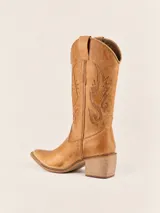 Bota texana de cuero color tostado con diseño bordado en la caña y punta fina.