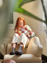 Sweater de punto con diseño geométrico en tonos celeste, marrón y beige.