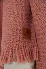 Ruana de tejido de punto con textura, color rosa claro, con flecos en el ruedo. Diseño versátil y envolvente, ideal para usar como abrigo ligero.