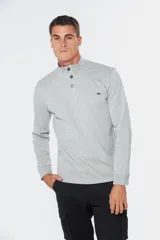 Remera de manga larga tipo buzo liviano, confeccionada en tejido jersey color gris melange. Presenta cuello mao con tapeta de tres botones y puños en rib.