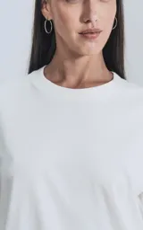 Remera de manga corta y cuello redondo, color blanco, con calce regular y un recorte sutil en la espalda.