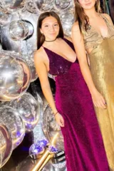 Vestido largo con escote en V, estampado en tonos rojizos y rosados, con un patrón ondulado. Presenta cut-outs laterales bajo el busto y breteles finos que se cruzan en la espalda.