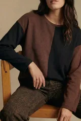 Sweater de algodón con diseño bicolor en bloques, combinando tonos marrón y negro. Presenta cuello redondo, mangas largas y una textura acanalada.