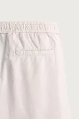 Pantalón de corte relajado confeccionado en una mezcla de algodón y lino. Presenta cintura elástica con cordón ajustable, bolsillos laterales y bolsillos traseros de vivo.