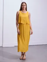 Vestido largo blanco de crepe con escote redondo y detalle de crochet en los hombros. Tiene corte en la cintura con punto smock.