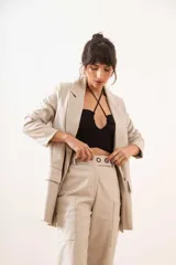 Pantalón de cuero sintético negro, de corte ancho, con bolsillos laterales y ruedo con dobladillo.