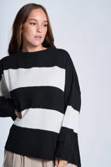 Sweater de punto con rayas horizontales anchas en blanco y negro. De corte amplio y relajado, brinda máxima comodidad sin perder el estilo. Su diseño atemporal lo convierte en una prenda versátil, ideal para combinar con jeans o pantalones para un look casual y abrigado en los días más frescos.