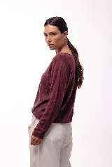 Remera de manga larga con cuello redondo, confeccionada en una mezcla de fibras naturales. Presenta un diseño básico y versátil, ideal para usar como prenda principal o como capa base.